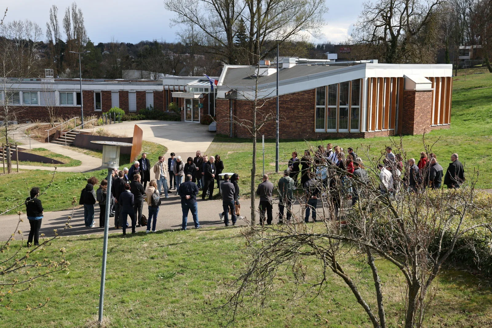 À l'initiative du personnel, de nombreuses personnes se sont réunies pour rendre hommage à Alexandre Heck devant la Maison de l'Université